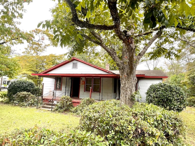 view of front of property featuring a front yard and covered porch