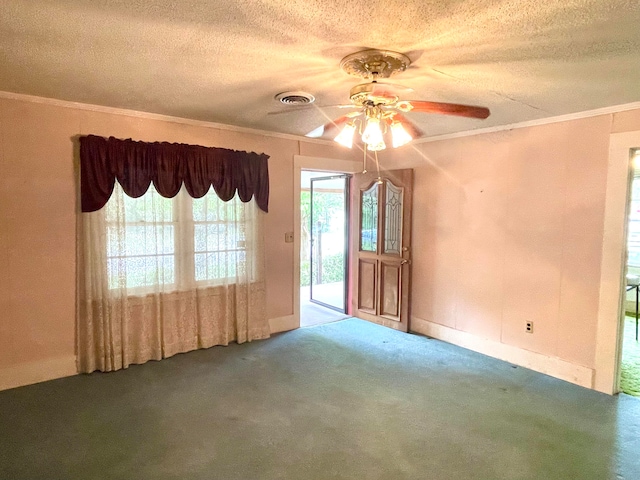 carpeted spare room featuring ornamental molding, a textured ceiling, and ceiling fan