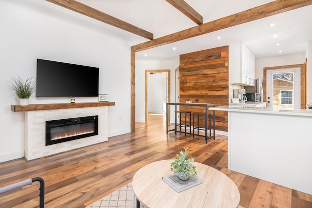 living room featuring beam ceiling and light wood-type flooring