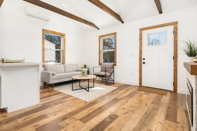 living room featuring plenty of natural light, lofted ceiling with beams, light hardwood / wood-style floors, and a wall mounted AC