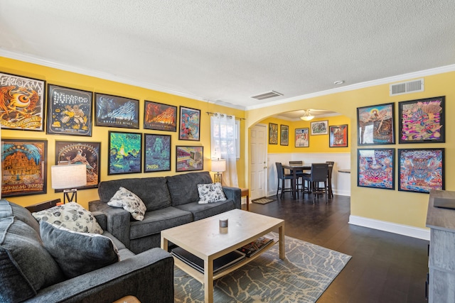 living room with ornamental molding, arched walkways, dark wood-style flooring, and visible vents