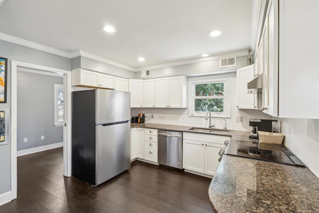 kitchen featuring dark wood finished floors, crown molding, stainless steel appliances, white cabinets, and a sink