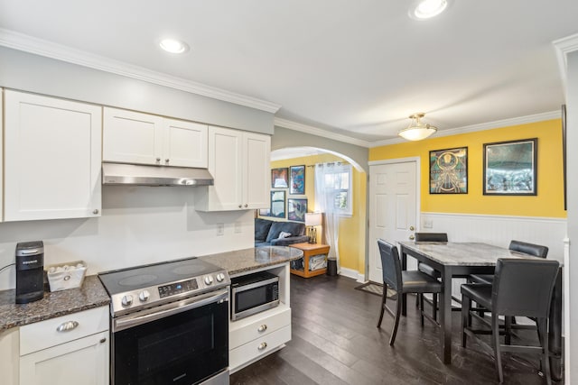 kitchen featuring arched walkways, white cabinets, ornamental molding, stainless steel appliances, and under cabinet range hood