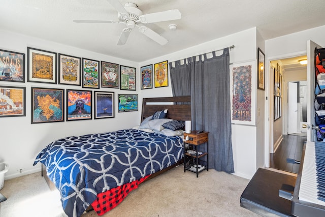 carpeted bedroom with a textured ceiling, a ceiling fan, and baseboards