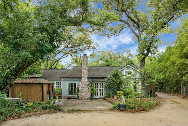 rear view of property with a gazebo, a patio, french doors, and a chimney