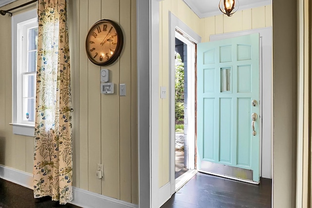 entrance foyer with baseboards, ornamental molding, and dark wood finished floors