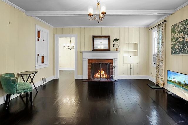 living room with an inviting chandelier, beam ceiling, a brick fireplace, hardwood / wood-style floors, and crown molding