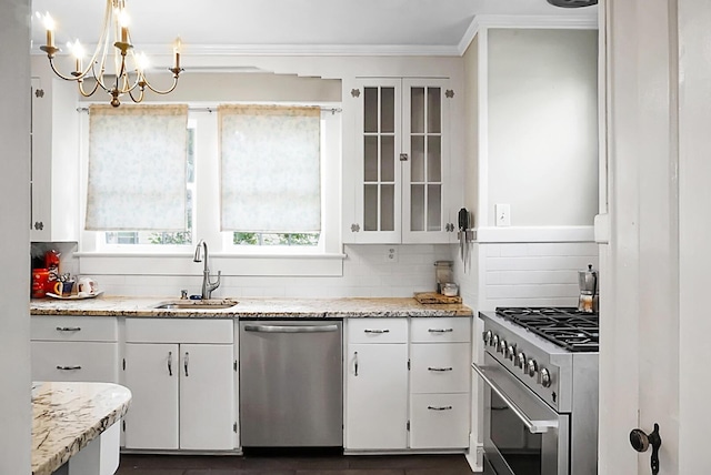 kitchen with a sink, backsplash, white cabinets, and appliances with stainless steel finishes