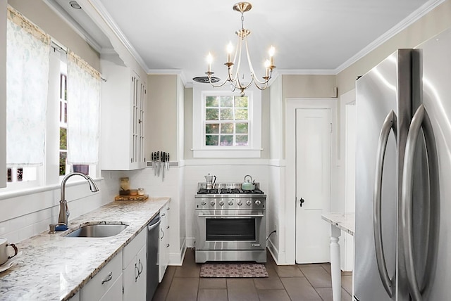 kitchen with an inviting chandelier, a sink, dark tile patterned flooring, decorative backsplash, and stainless steel appliances