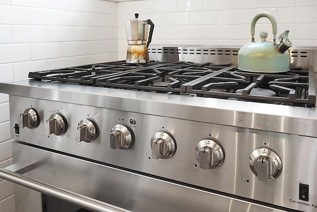 details featuring high end stove and decorative backsplash
