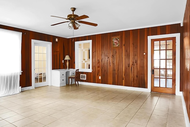spare room with light tile patterned floors, wooden walls, and ceiling fan