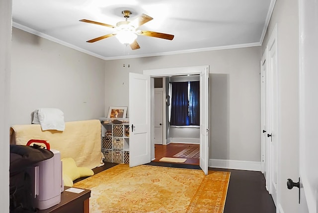 bedroom with baseboards, ornamental molding, ceiling fan, and wood finished floors