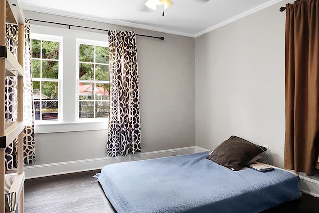 bedroom featuring baseboards, ceiling fan, crown molding, and wood finished floors