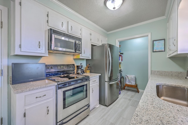 kitchen with crown molding, light countertops, a sink, white cabinetry, and appliances with stainless steel finishes