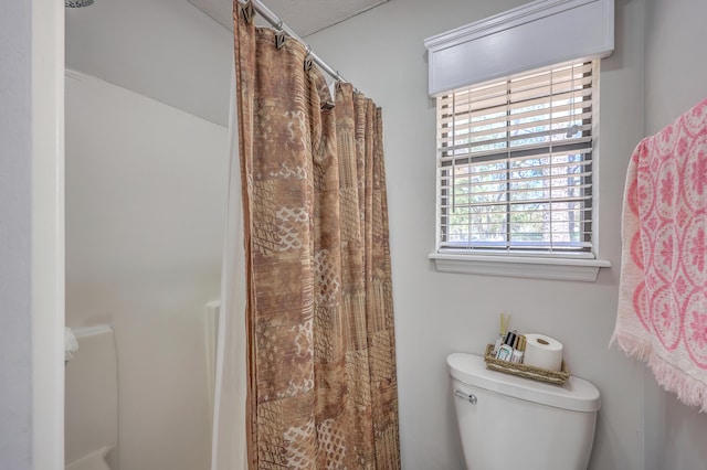 bathroom with a shower with curtain and toilet