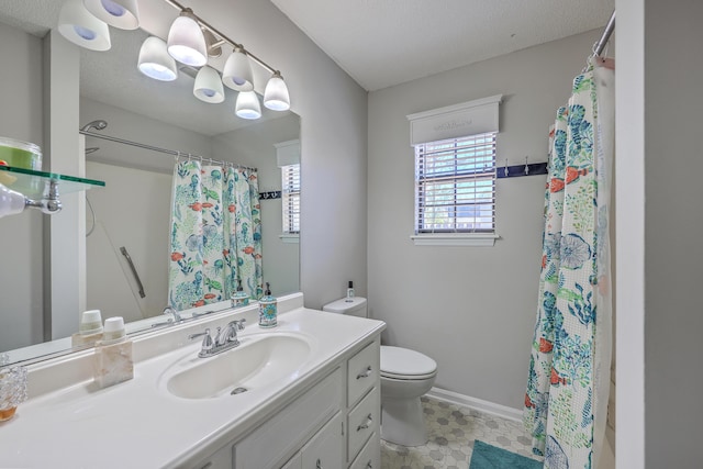 bathroom with toilet, vanity, baseboards, and a textured ceiling