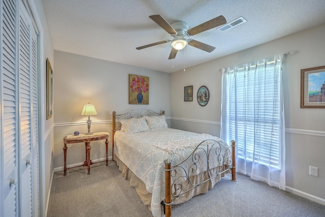 bedroom featuring carpet, baseboards, a textured ceiling, and visible vents