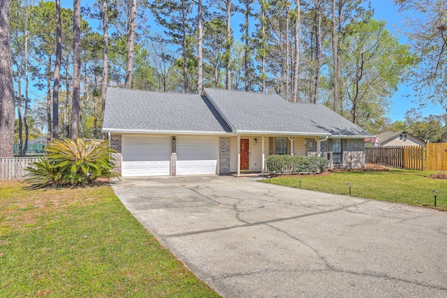 ranch-style house with driveway, an attached garage, fence, and a front lawn