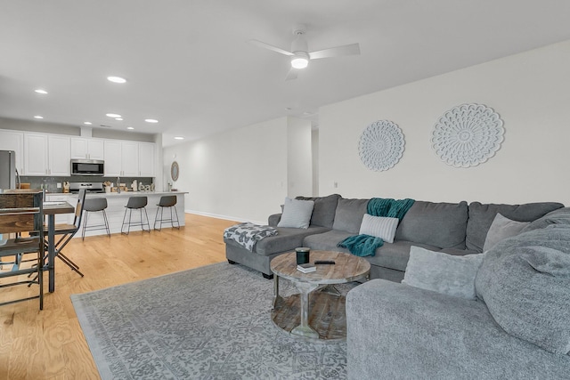 living room with ceiling fan and light hardwood / wood-style floors