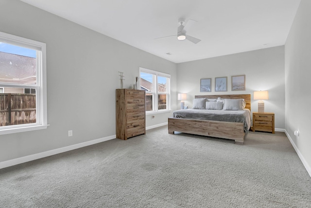 bedroom with multiple windows, ceiling fan, and carpet