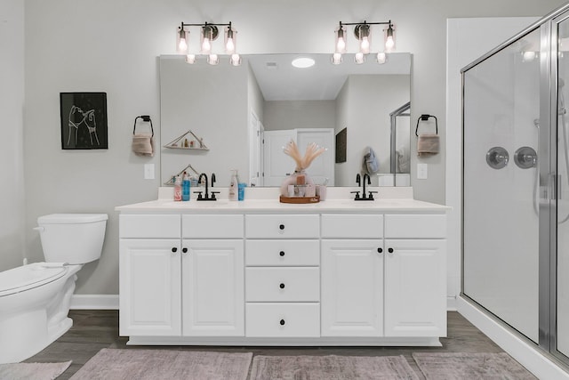 bathroom with hardwood / wood-style floors, vanity, and walk in shower