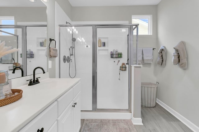 bathroom featuring vanity, hardwood / wood-style flooring, and a shower with shower door