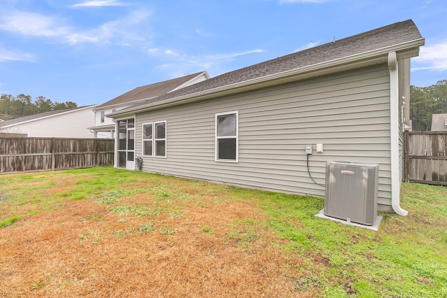 back of property featuring a yard and central air condition unit