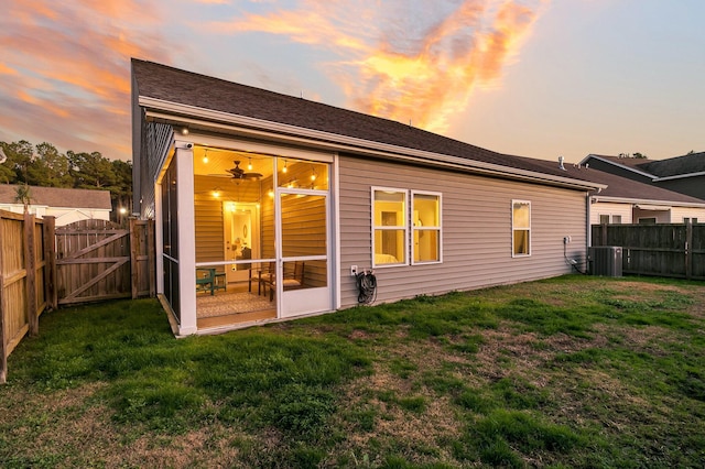 back house at dusk with a lawn