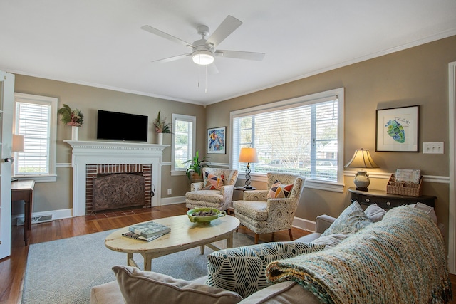 living room with ornamental molding, a brick fireplace, wood finished floors, and baseboards