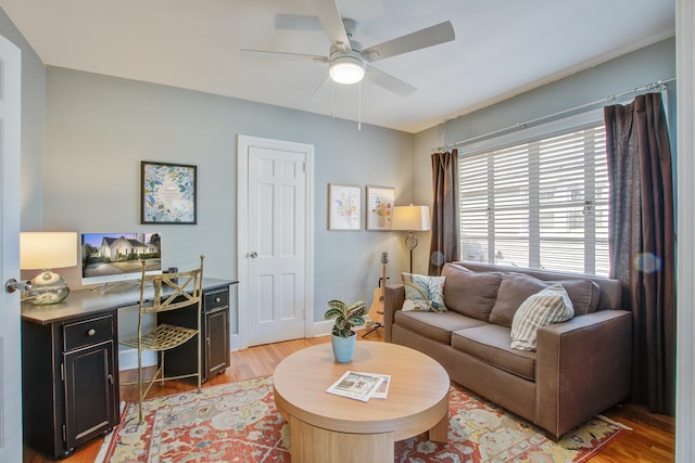 living room featuring light wood-style flooring and a ceiling fan