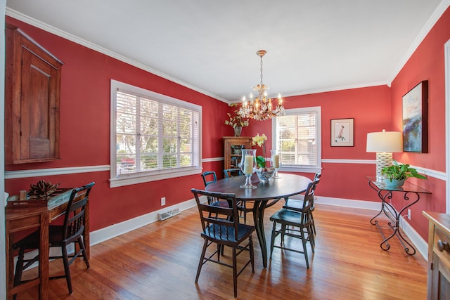 dining space with light wood-type flooring, baseboards, visible vents, and crown molding