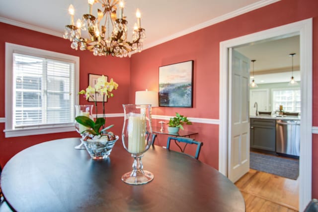 dining room featuring a wealth of natural light, crown molding, and wood finished floors