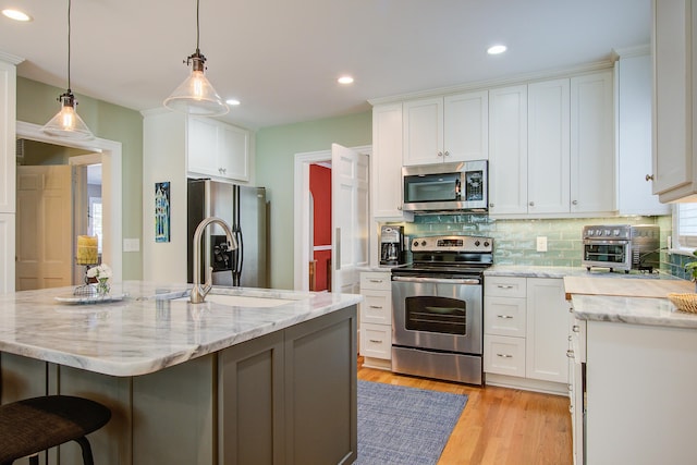 kitchen with stainless steel appliances, backsplash, and white cabinets