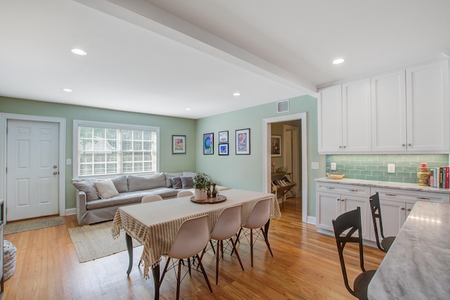 dining area featuring light wood-style flooring, recessed lighting, visible vents, baseboards, and beam ceiling