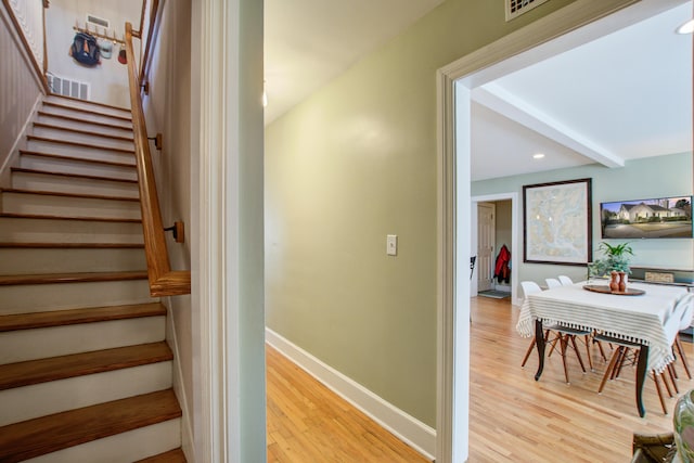 stairway with recessed lighting, baseboards, wood finished floors, and beamed ceiling