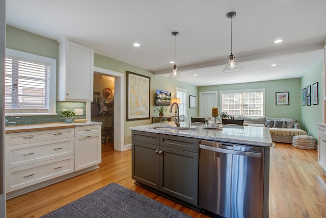 kitchen featuring light wood-style floors, open floor plan, white cabinets, a sink, and dishwasher