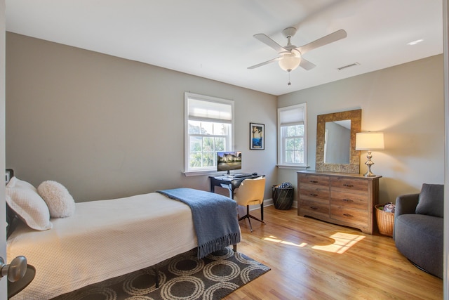 bedroom with a ceiling fan, visible vents, and light wood-style floors