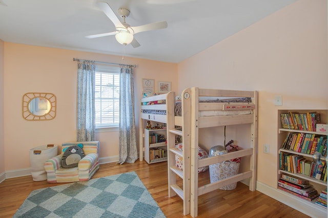 bedroom with ceiling fan, wood finished floors, and baseboards