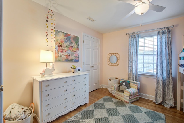 sitting room with light wood-style floors, visible vents, baseboards, and a ceiling fan