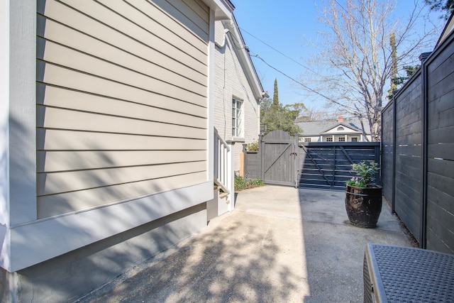 view of property exterior with a patio area, a gate, and fence