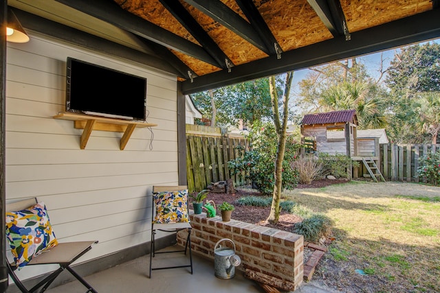 view of patio featuring fence and an outdoor structure