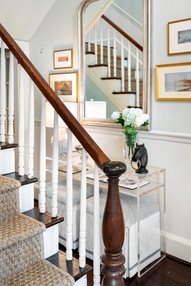 staircase featuring vaulted ceiling and hardwood / wood-style flooring