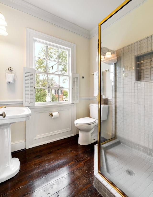 bathroom featuring wood-type flooring, walk in shower, ornamental molding, and toilet