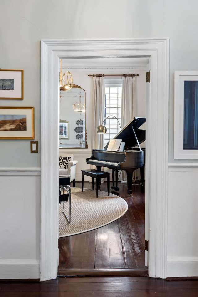 miscellaneous room with dark hardwood / wood-style floors and an inviting chandelier