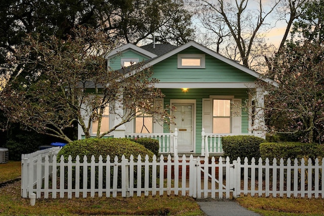 view of front facade with a porch and a fenced front yard