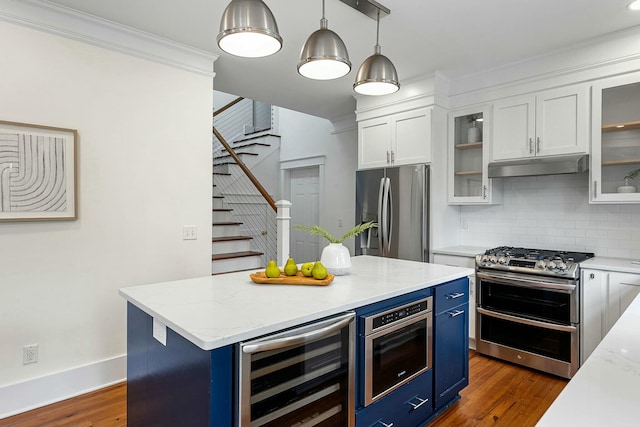 kitchen featuring beverage cooler, under cabinet range hood, white cabinets, stainless steel appliances, and blue cabinets