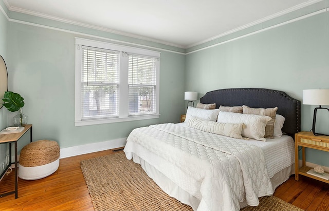 bedroom featuring wood finished floors, baseboards, and ornamental molding