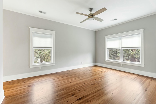 spare room featuring visible vents, baseboards, crown molding, and hardwood / wood-style flooring