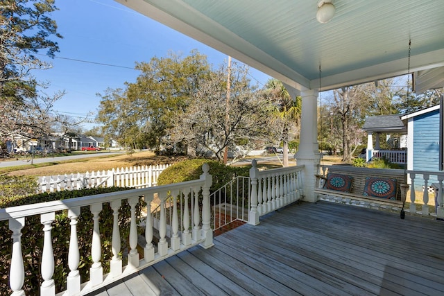 wooden terrace featuring fence and covered porch