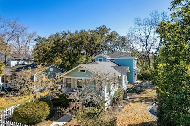 view of front of house featuring roof with shingles and fence